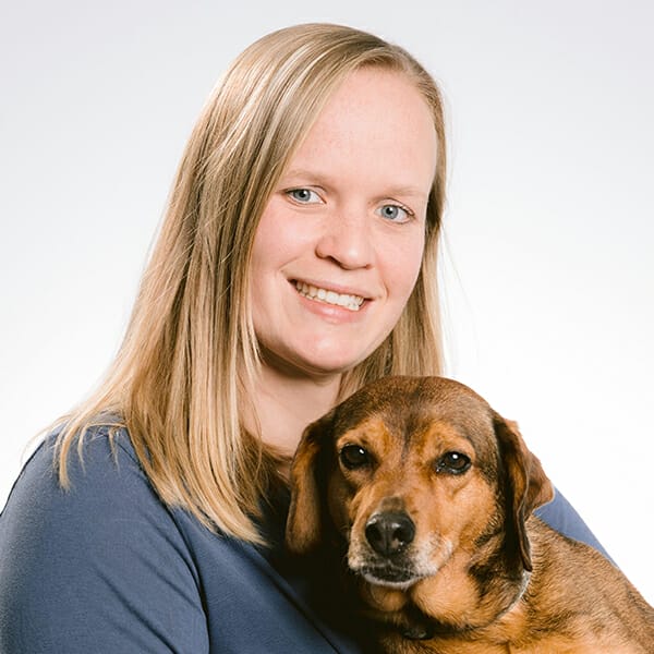 Emergency Medicine Veterinarian and Medical Director, Dr. Ellen Neal, holding her brown pet dog and smiling